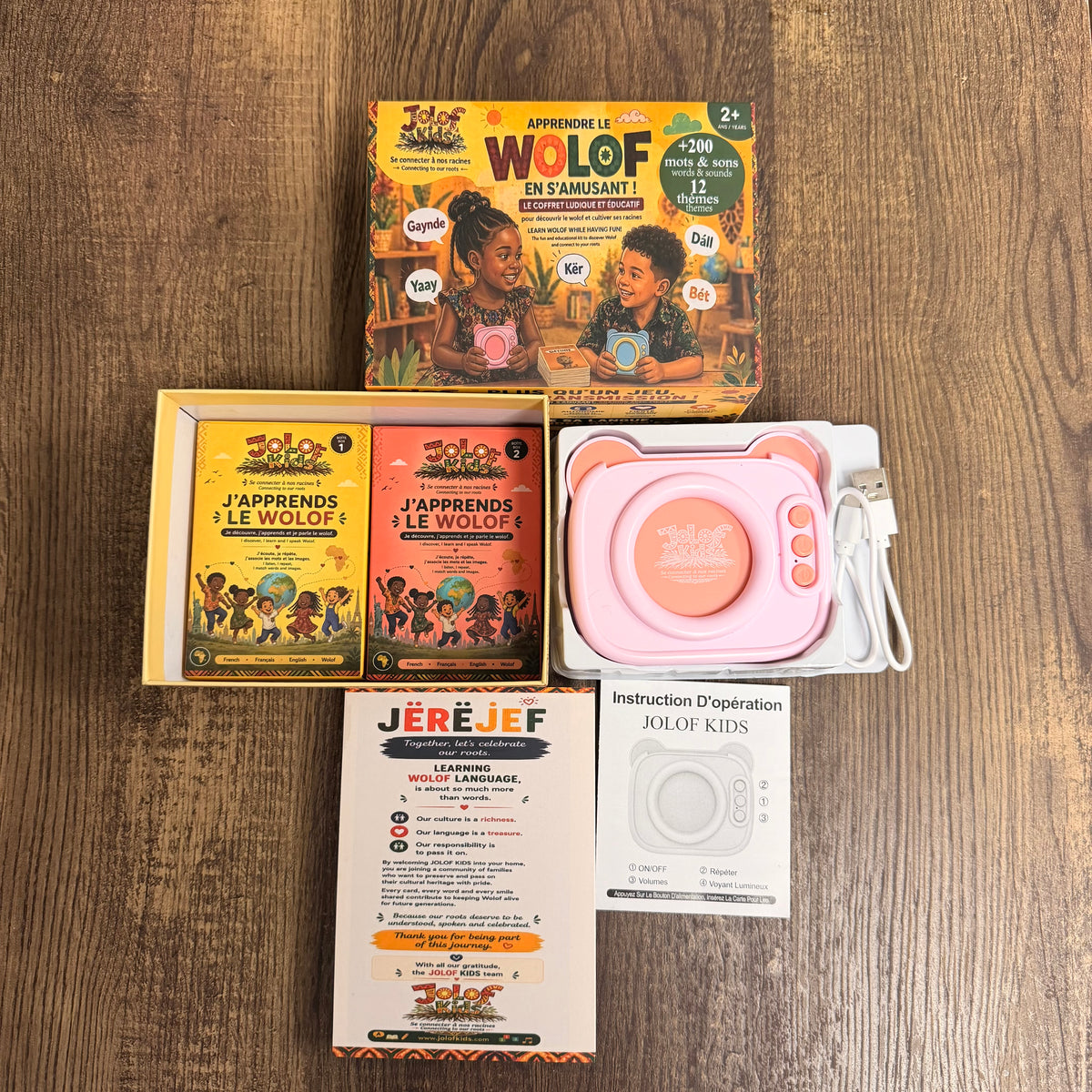 Contenu complet du coffret JOLOF Kids : lecteur audio rose, câble USB, deux boîtes de cartes, notice et carte de remerciement
