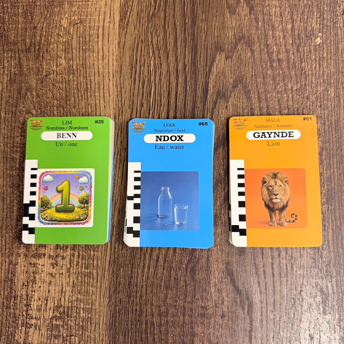 Trois cartes JOLOF Kids plastifiées : Benn (un), Ndox (eau) et Gaynde (lion), avec traduction en français et en anglais